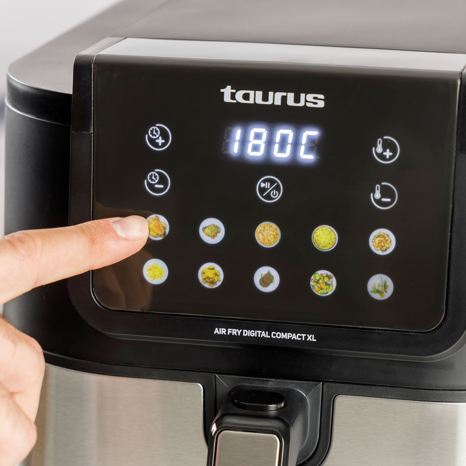 Ręka dotyka panelu sterowania czarnej frytkownicy beztłuszczowej Taurus Air Fry Digital Compact XL.