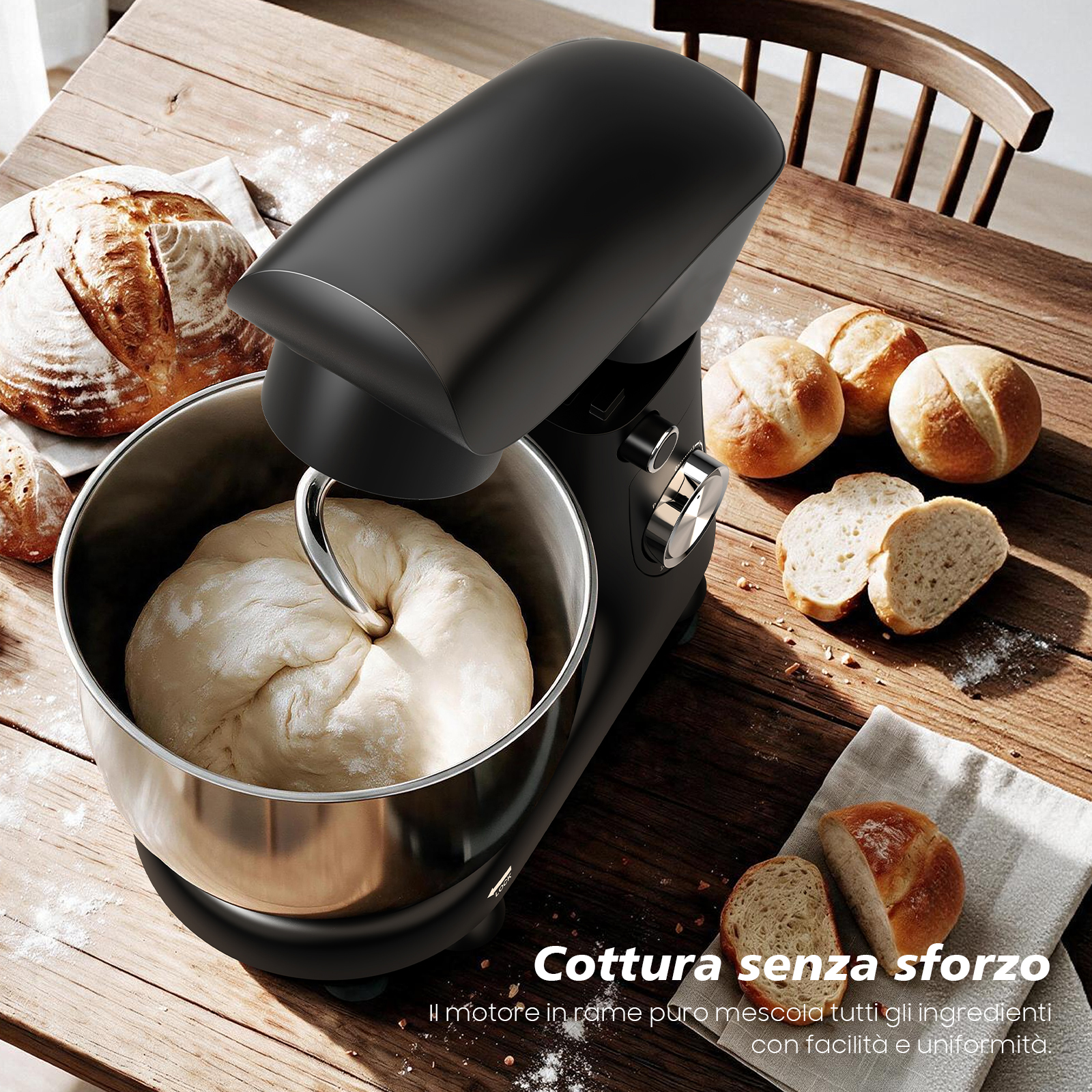 Una impastatrice nera su un tavolo di legno con pane fresco e impasto nella ciotola.