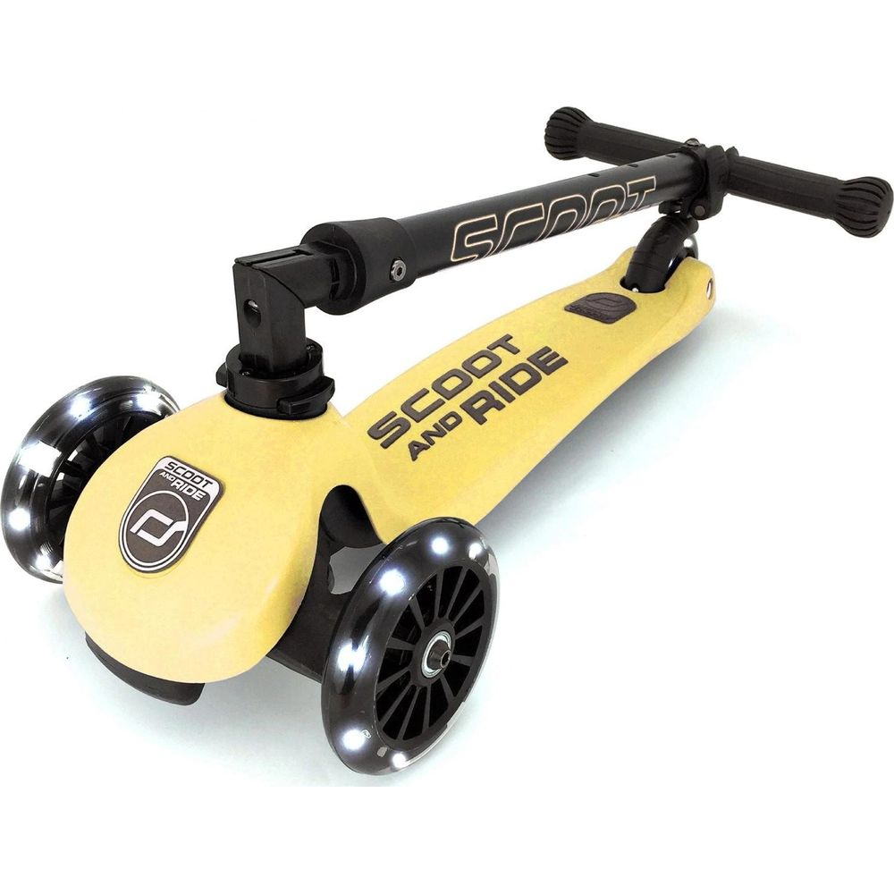 Gelber Scoot and Ride Kinderroller mit drei beleuchteten Rädern und schwarzem T-Lenker.