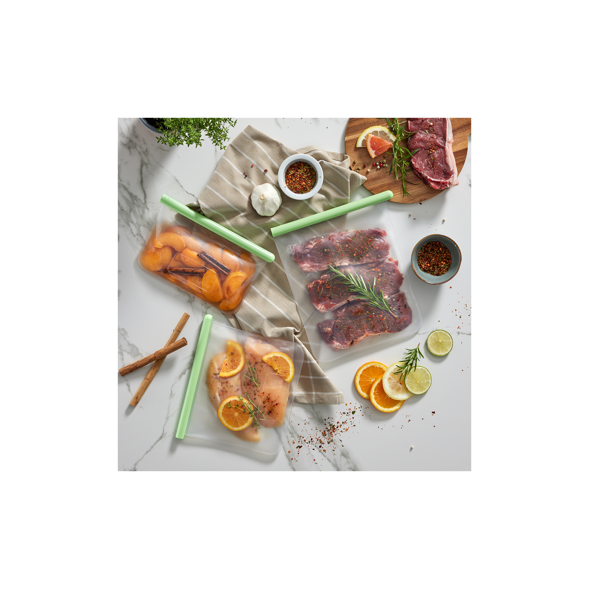 Silikonbeutel mit mariniertem Fleisch, Früchten und Gewürzen auf einer Marmorarbeitsplatte.
