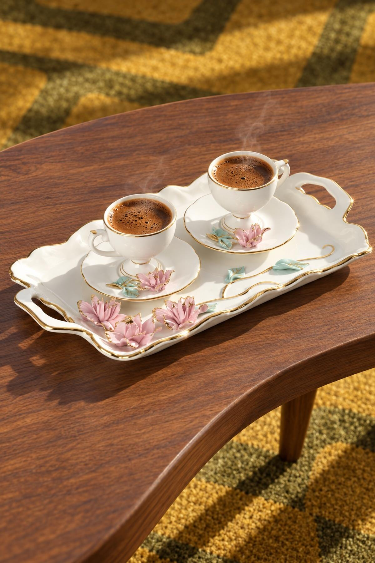 Ahşap sehpa üzerinde çiçek motifli beyaz porselen tepside iki fincan dumanı tüten kahve.