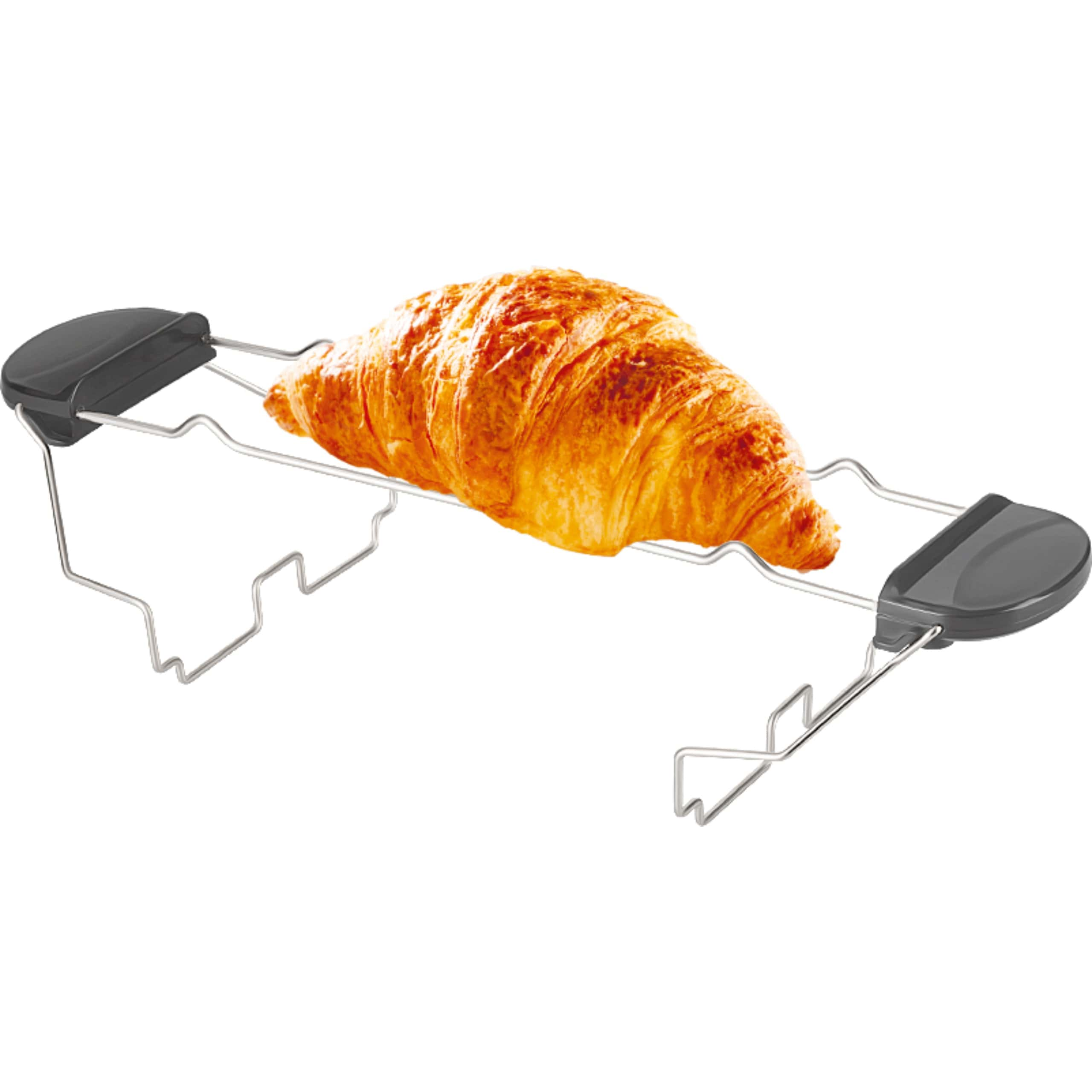 A golden croissant rests on a wire bread warming rack with black handles against a white background.