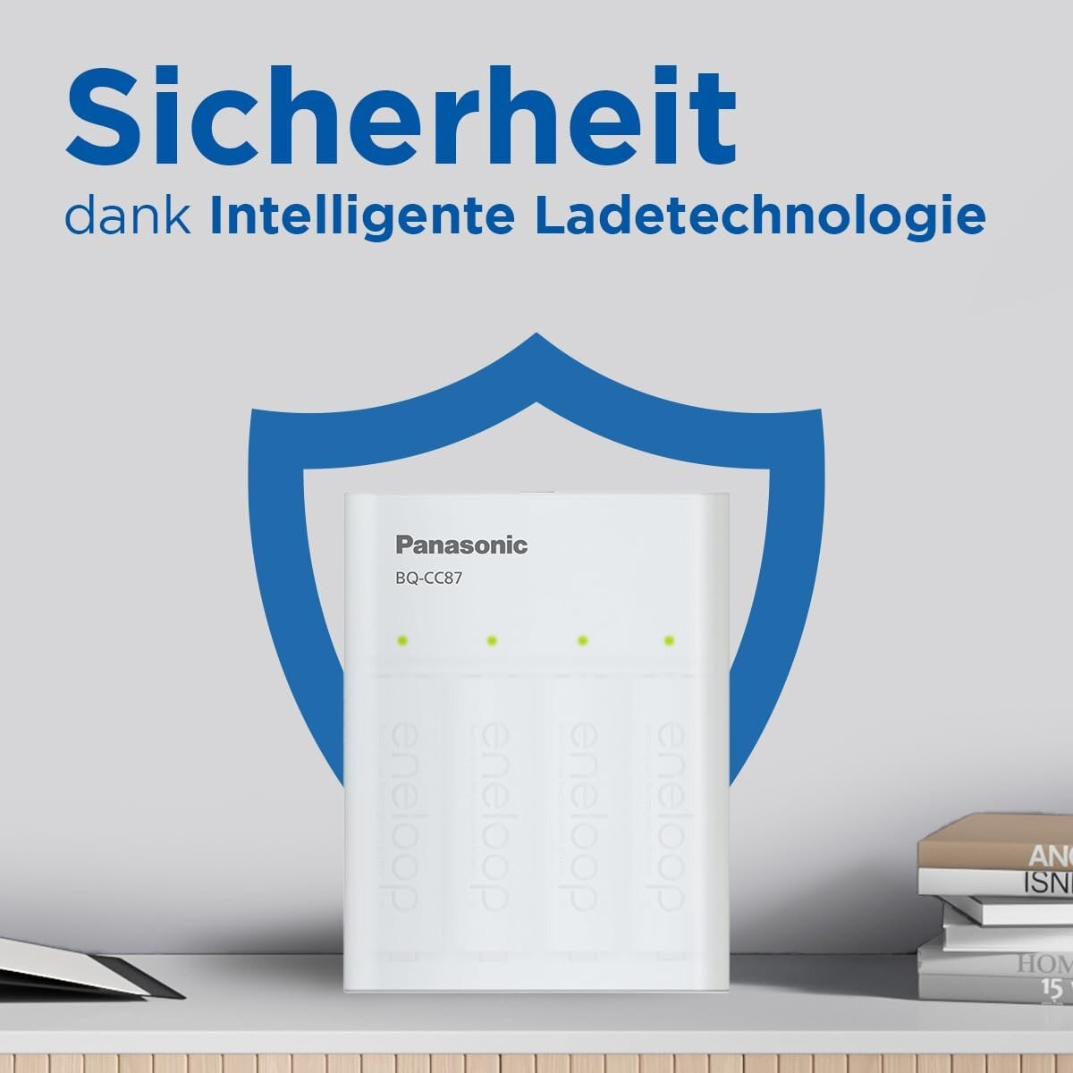 Ładowarka Panasonic BQ-CC87 stoi na stole przed niebieską tarczą i książkami.