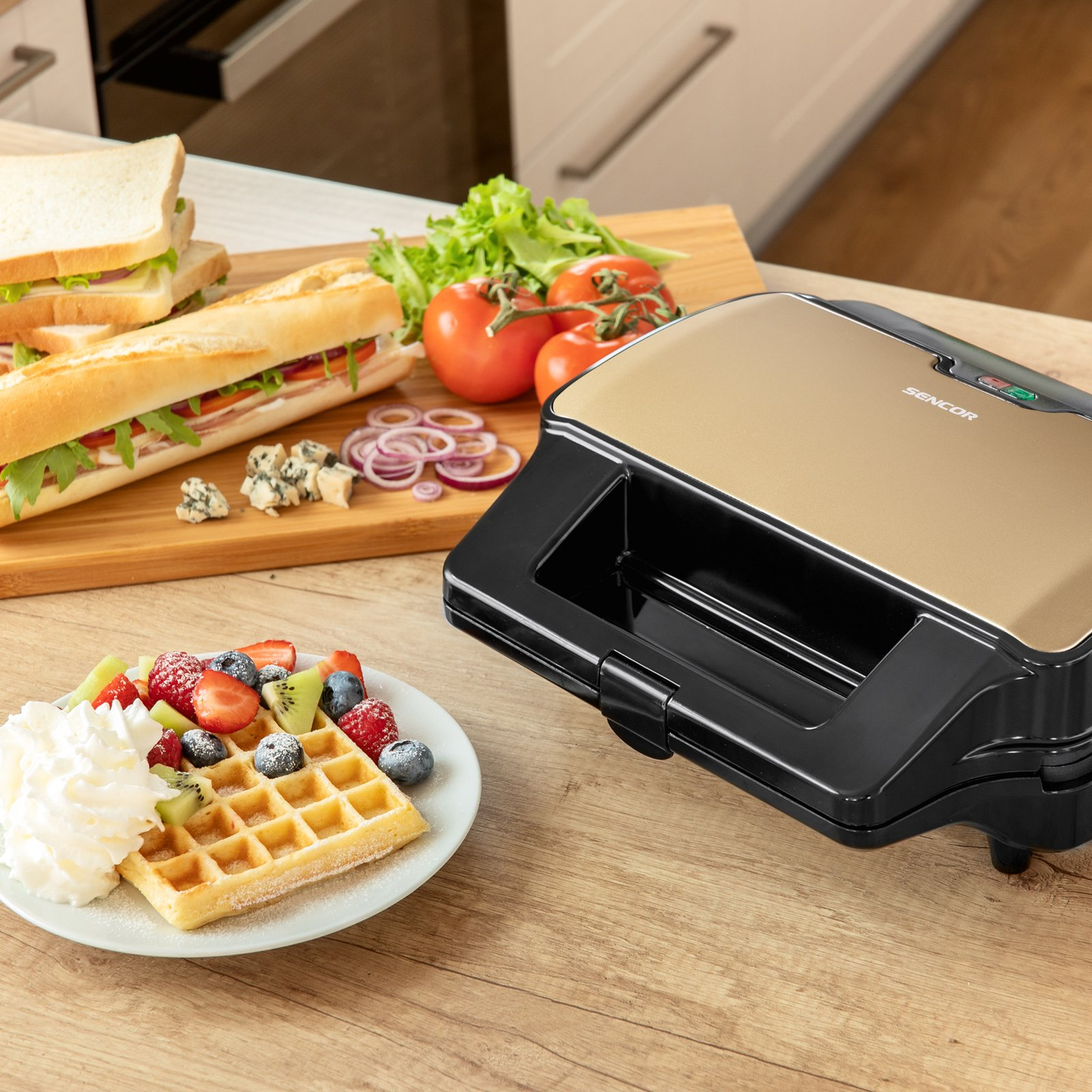 Ein Sencor-Sandwichmaker, eine Waffel mit Früchten und Sahne auf einem Teller sowie Sandwiches auf einem Holzbrett.
