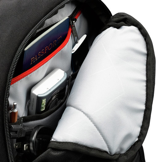 Offener schwarzer Rucksack mit organisierten Fächern für Pass, Kamera, Stift und Kabel.