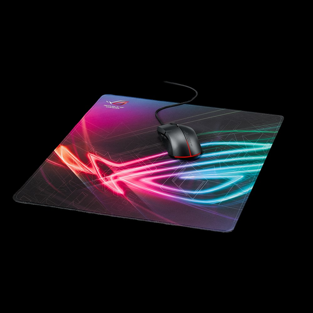 Une souris de jeu filaire repose sur un tapis coloré et lumineux sur fond noir.