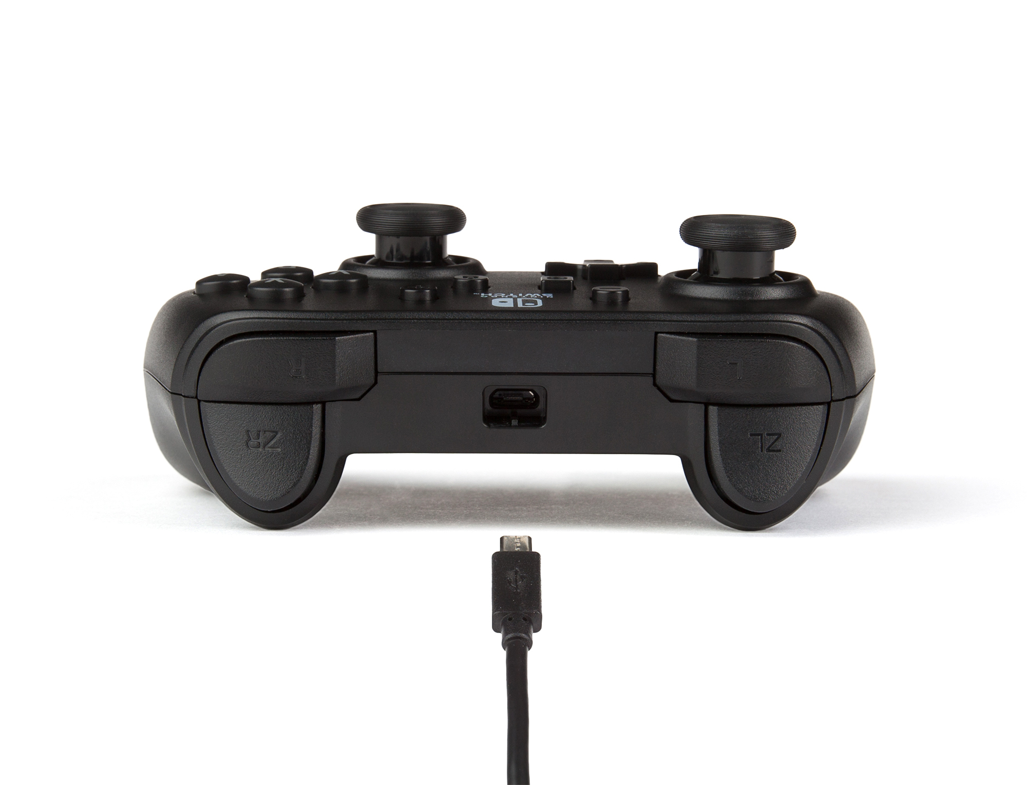 Un mando de juego negro con dos joysticks y botones superiores, mostrado con un cable USB alineado debajo.