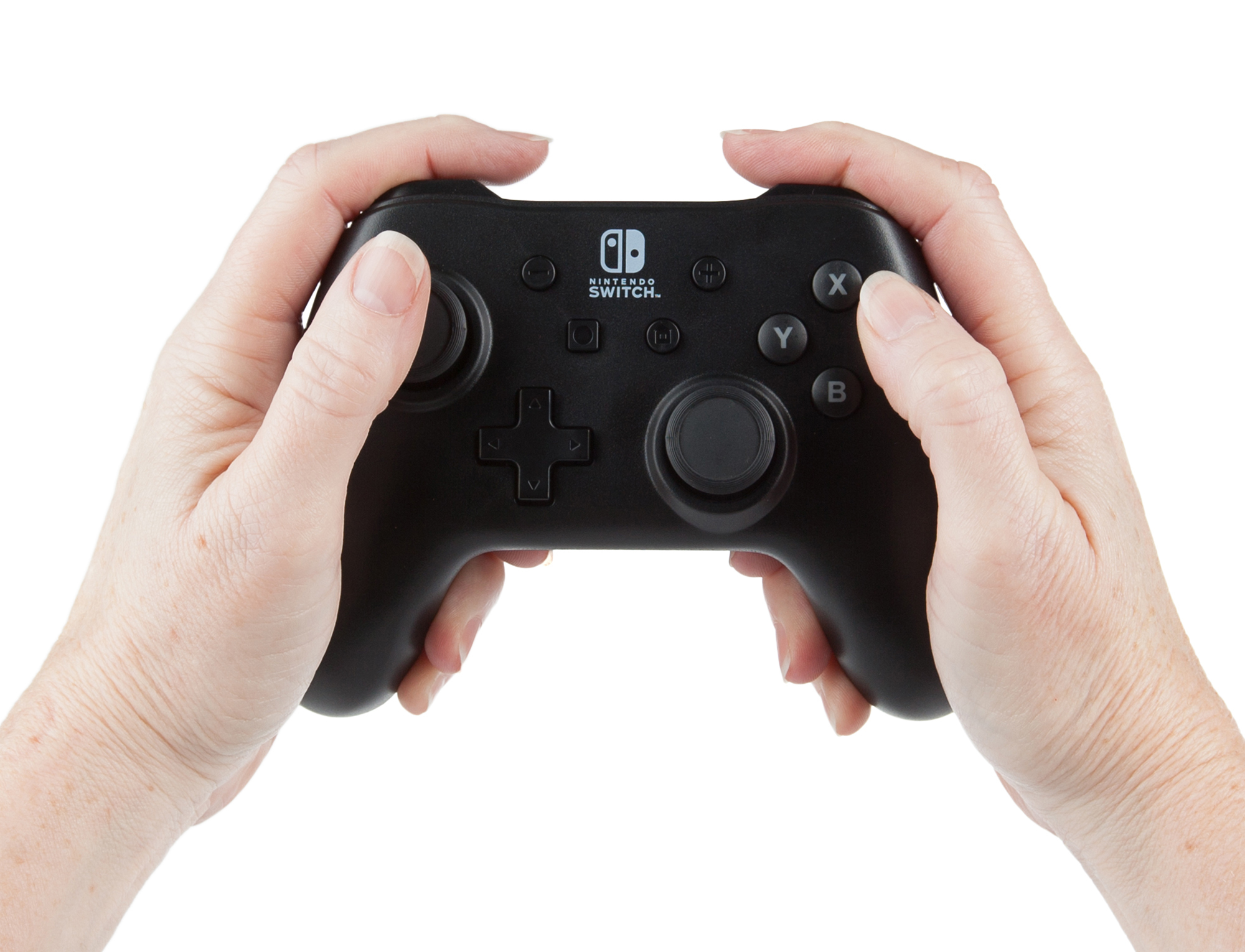 Dos manos sosteniendo un controlador negro Nintendo Switch Pro sobre fondo blanco.