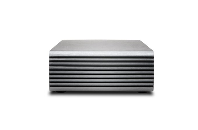 Un amplificatore elettronico in metallo argentato con alette di raffreddamento orizzontali su sfondo bianco.