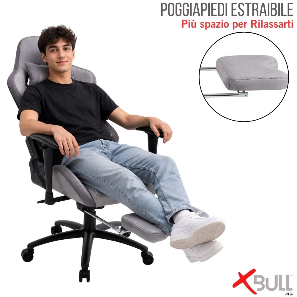 Un giovane siede su una sedia da gaming grigia con poggiapiedi estraibile, rilassato.
