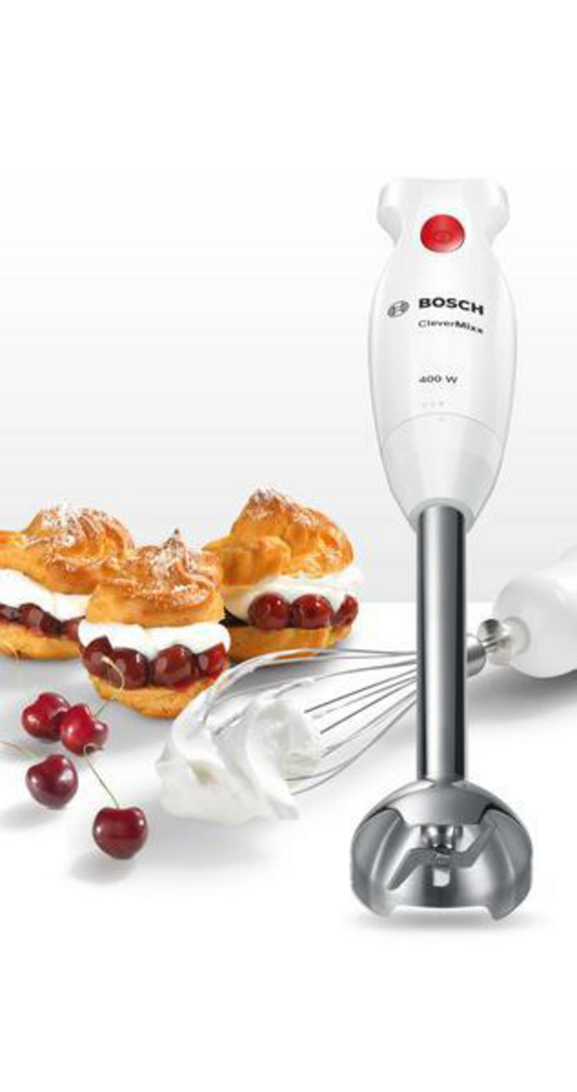 Ein weißer Bosch-Stabmixer mit Zubehör, Himbeeren und Windbeuteln auf weißem Hintergrund.