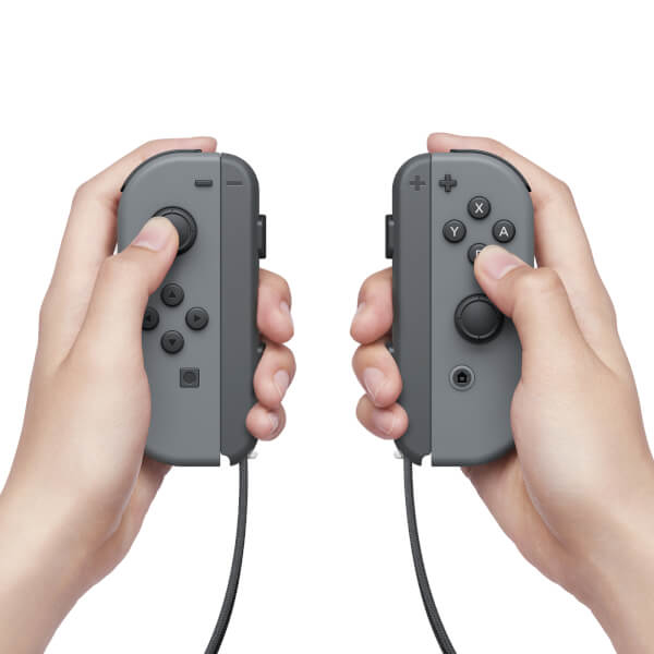 Due mani che tengono controller di gioco grigi con pulsanti e joystick su sfondo bianco.