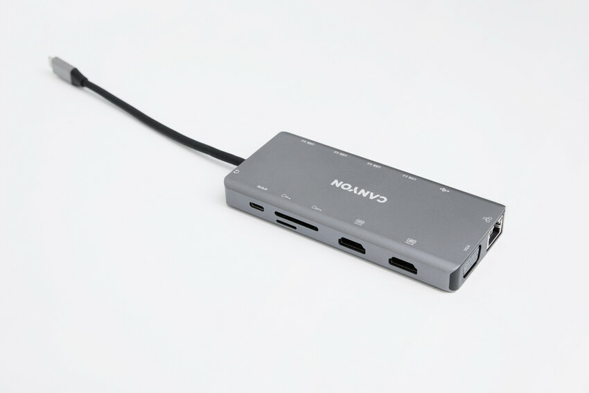 Szary hub wieloportowy USB-C marki Canyon z kablem na białym tle.