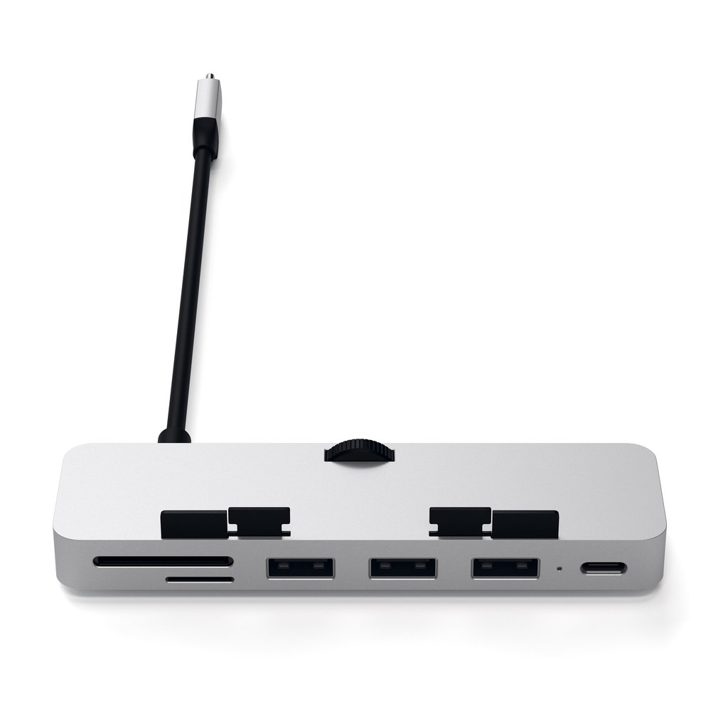 Un concentrador USB-C plateado con múltiples puertos, ranuras y un cable adjunto sobre un fondo blanco.