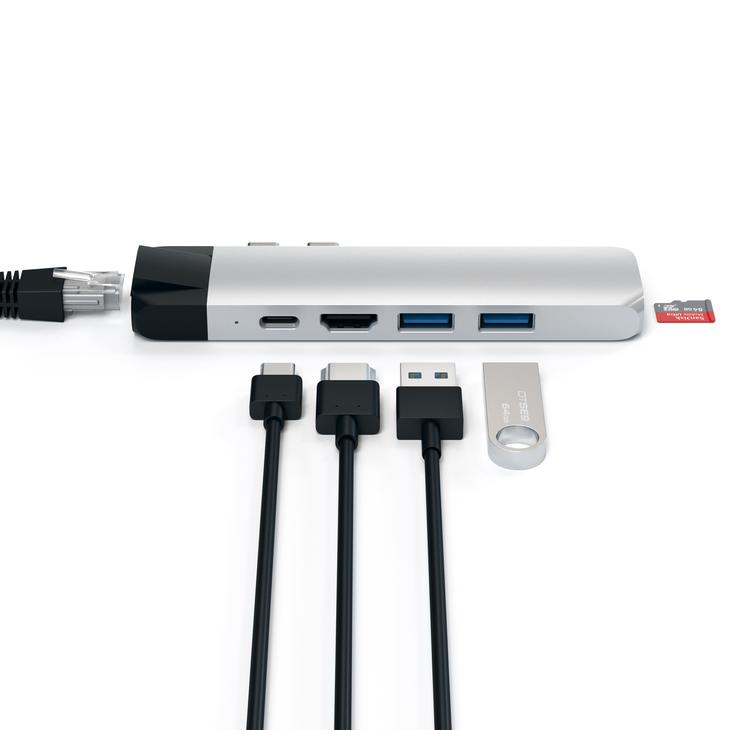 A silver USB-C hub with connected cables, SD cards, and ports displayed against a white background.