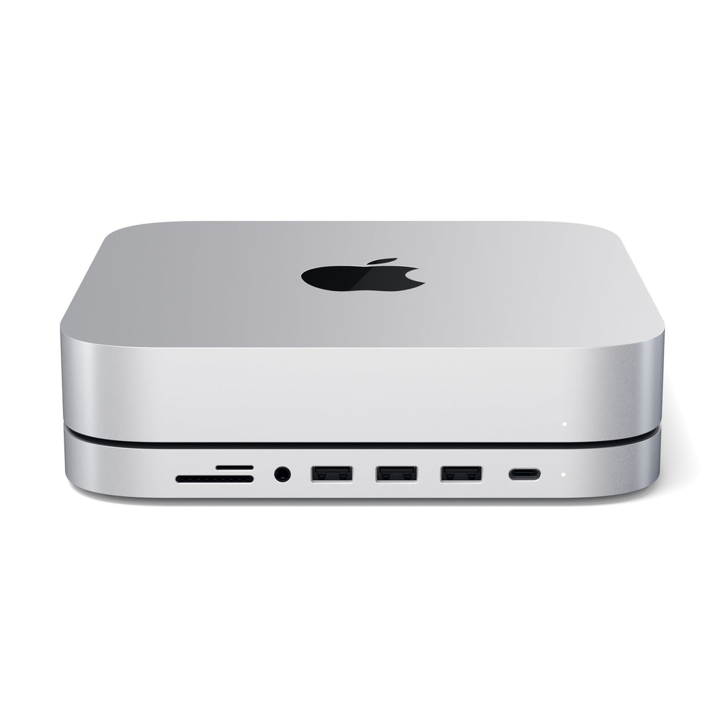 Un Apple Mac Mini plateado con una base accesoria con múltiples puertos USB y ranura para tarjeta SD sobre fondo blanco.