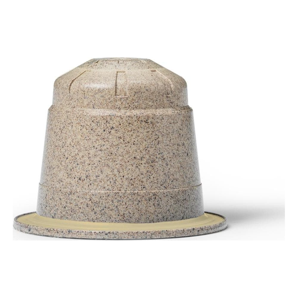 Una capsula di caffè beige maculata su sfondo bianco.
