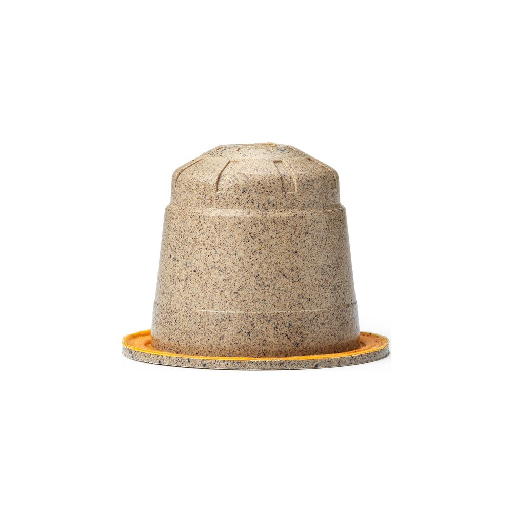 Una capsula di caffè beige screziata con un bordo giallo su sfondo bianco.