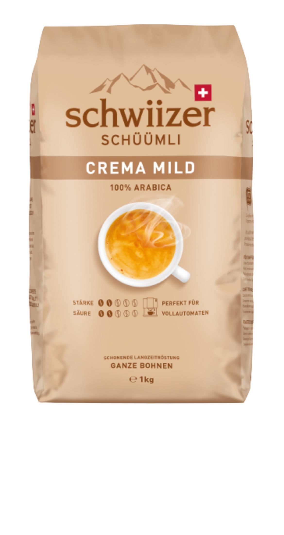 Eine beige Kaffeetüte von Schwiizer Schüümli mit dem Text Crema Mild, einer Kaffeetasse und Bergmotiven.