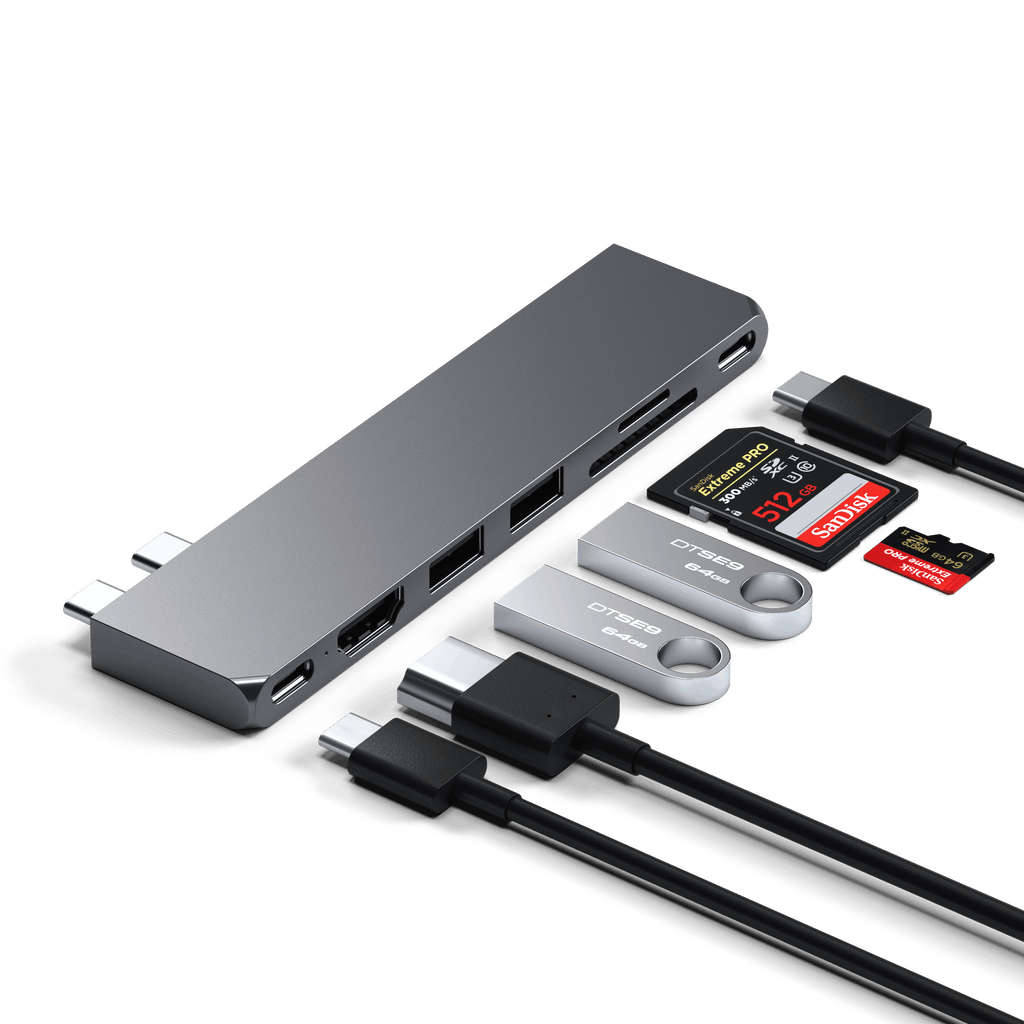 Szary hub USB-C z wieloma portami, dwoma dyskami flash USB, kartami pamięci i kablami na białym tle.