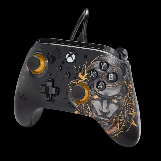 Ein schwarzer Xbox-Controller mit goldenen Akzenten und kunstvollem Gesichtsmotiv auf dunklem Hintergrund.