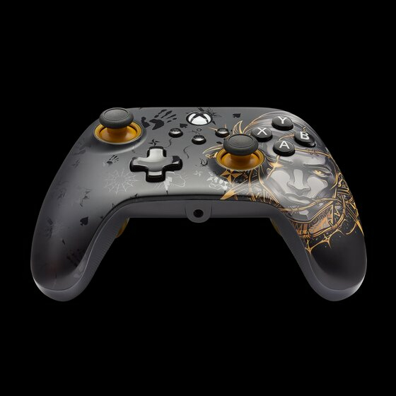 Ein schwarz-goldener Xbox-Controller mit stilisierter Charakterkunst und Tattoos vor dunklem Hintergrund.