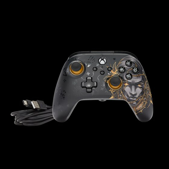 Ein schwarzer Xbox-Controller mit goldener Grafik und einem angeschlossenen USB-Kabel.