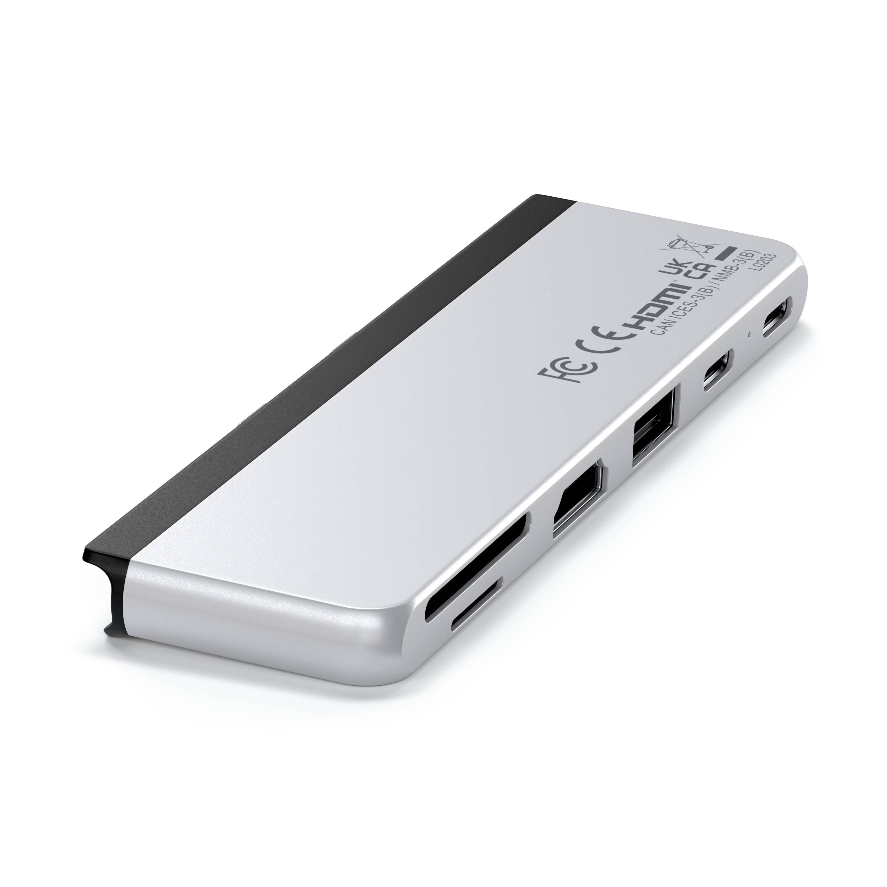 Concentrador USB-C plateado con múltiples puertos, ranuras para tarjetas y marcas reglamentarias.