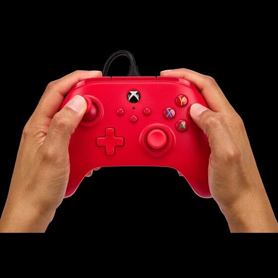 Hände halten einen roten Xbox-Controller vor schwarzem Hintergrund.