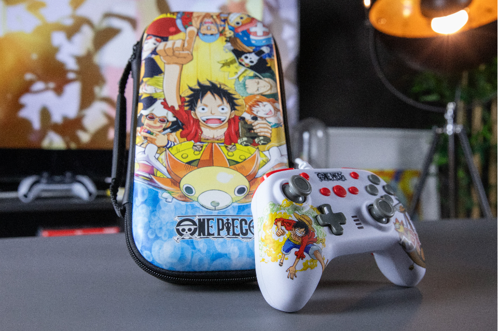 Eine One Piece-Konsolentasche und ein weißer Controller mit Luffy-Grafik stehen auf einem Tisch.