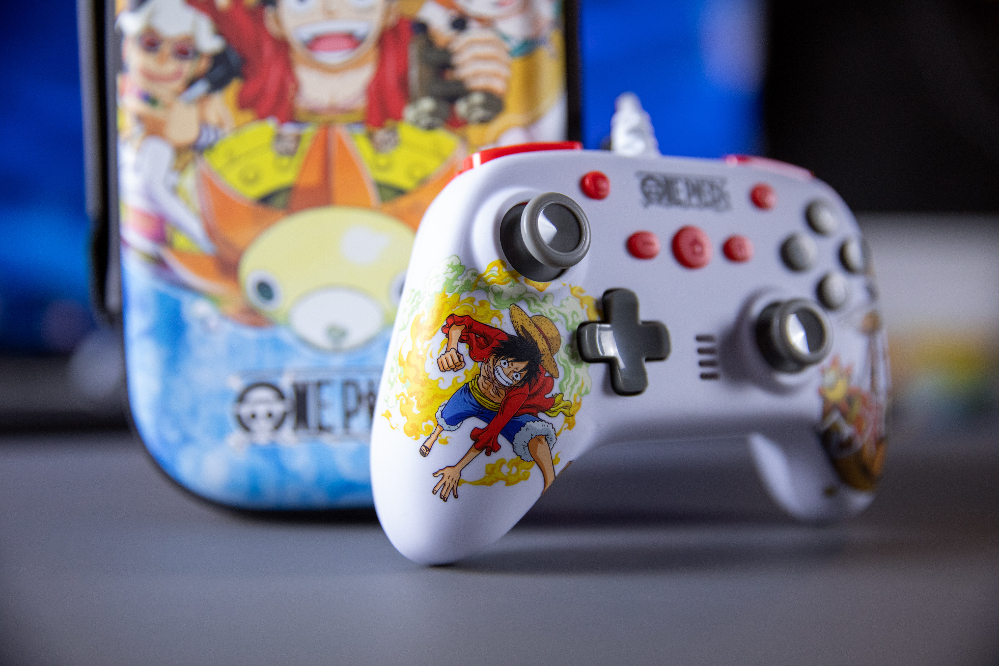 Ein weißer One Piece-Anime-Gaming-Controller und eine Tasche liegen auf einer grauen Oberfläche.