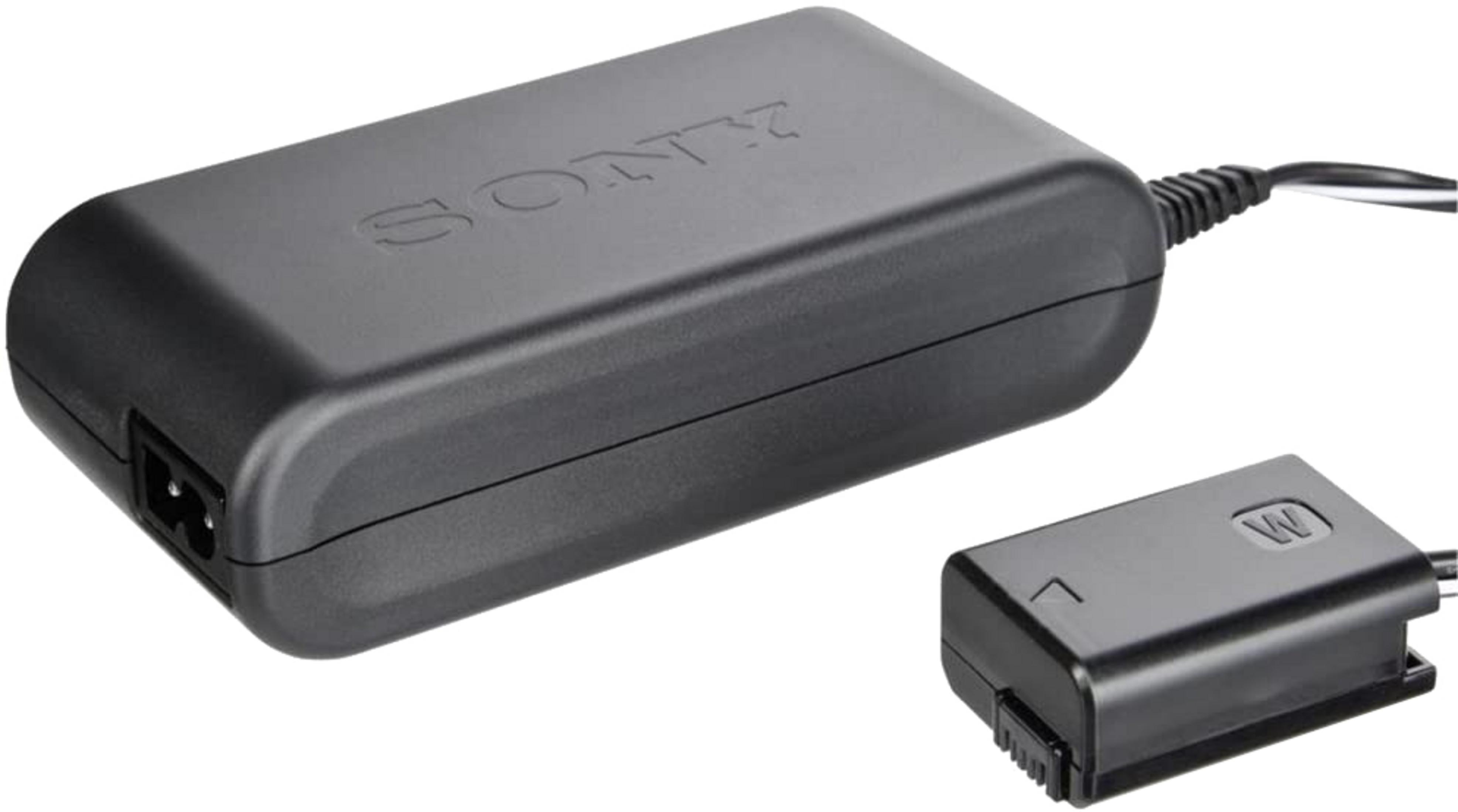 Ein schwarzes Sony Netzteil und ein kleinerer Dummy-Akku-Anschluss mit Kabeln auf weißem Hintergrund.