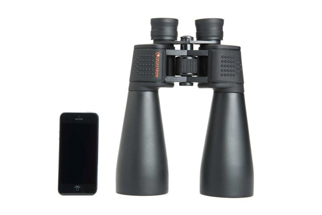 Schwarzes Fernglas und Smartphone nebeneinander auf weißem Hintergrund.