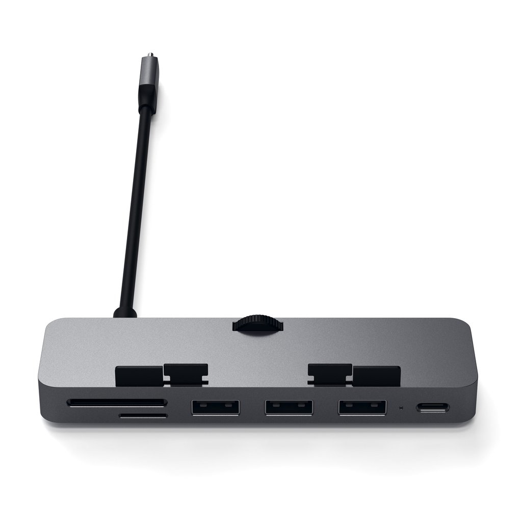 Un concentrador USB-C gris con múltiples puertos, un lector de tarjetas y un cable en fondo blanco.