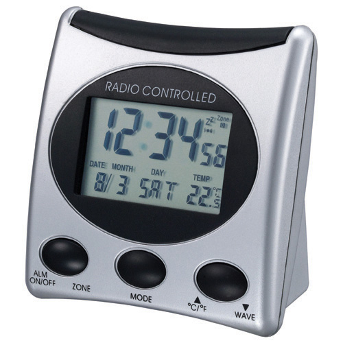 Un reloj despertador digital radiocontrolado plateado con borde de pantalla negro y tres botones de control.