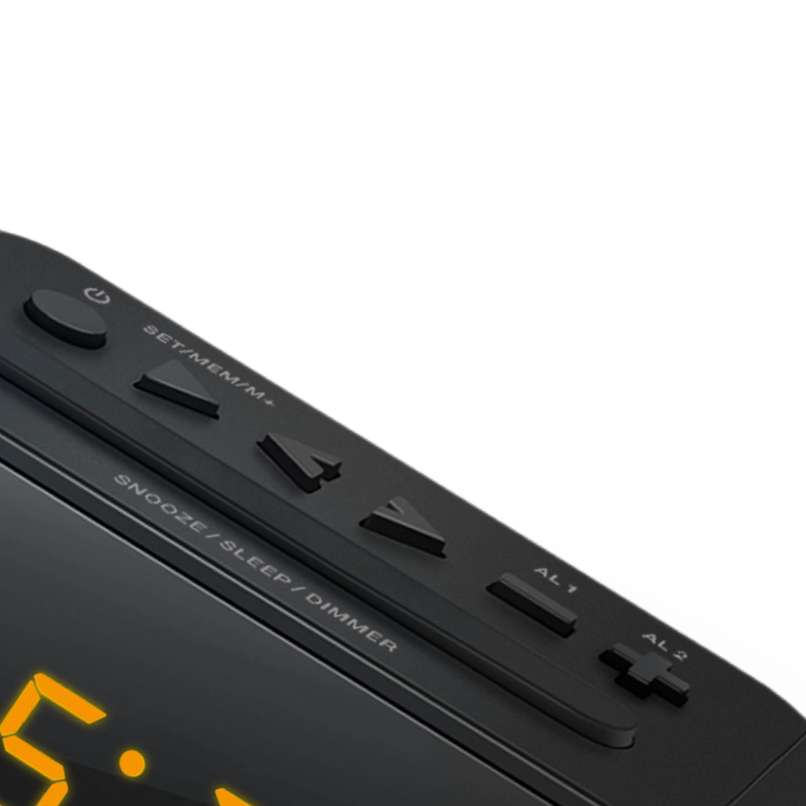 Primer plano del panel de control superior de un reloj digital negro con botones sobre fondo blanco.