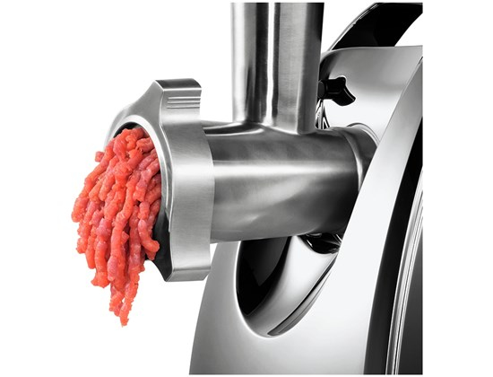 Frisches Hackfleisch kommt aus einem modernen Fleischwolf aus Edelstahl.