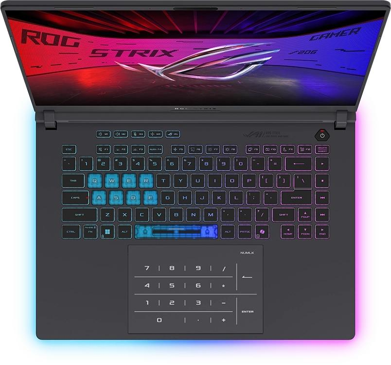 Işıklı klavyeye ve ekranında ROG Strix duvar kağıdına sahip açık bir oyun dizüstü bilgisayarı.