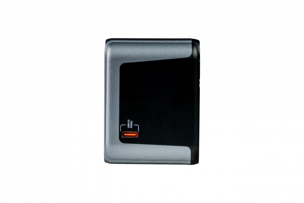Un adaptador de corriente negro y gris con un puerto USB-C visible sobre fondo blanco.