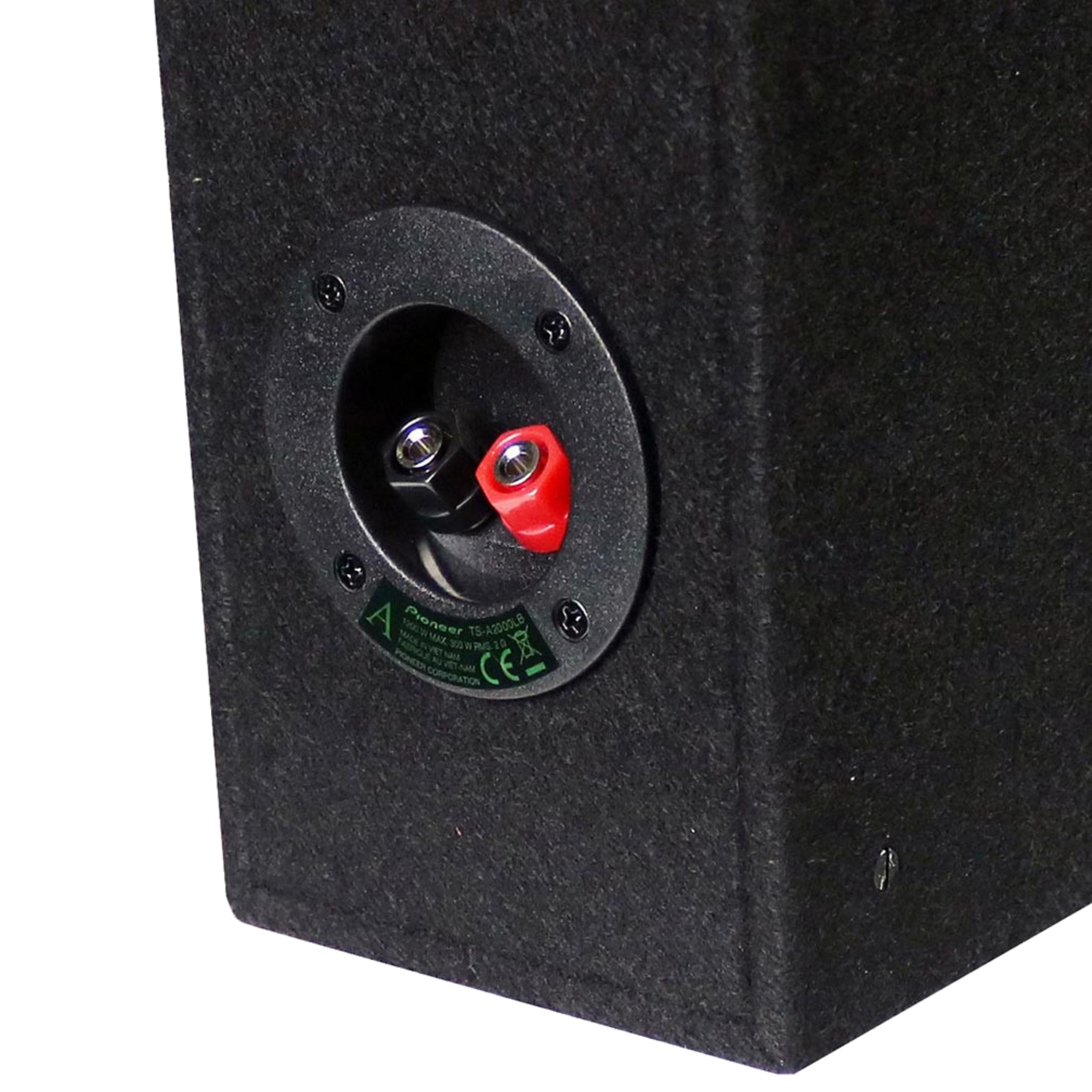 Rückseite einer schwarzen Lautsprecherbox mit roten und schwarzen Anschlüssen sowie einem grünen Etikett.