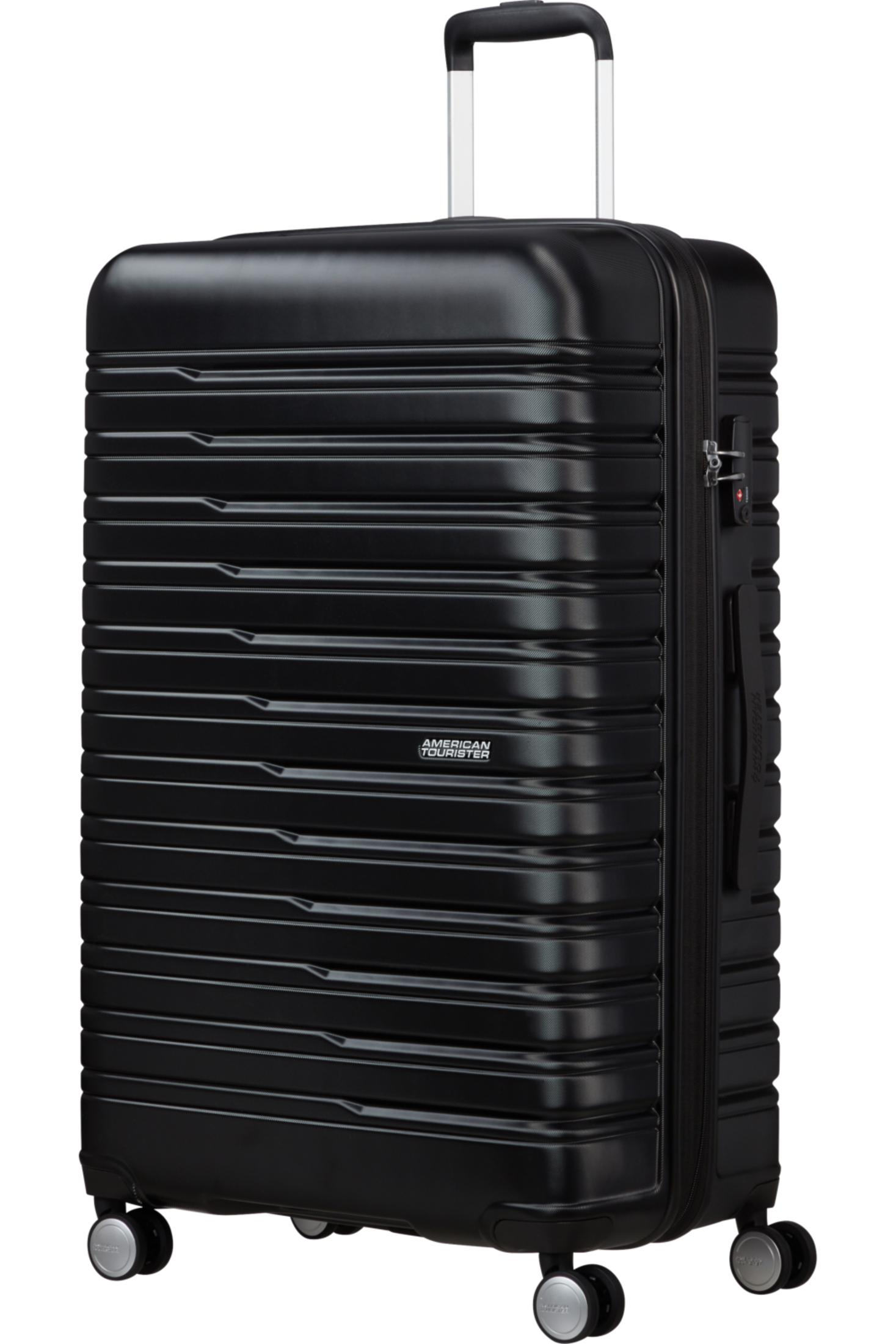 Czarna twarda walizka American Tourister z poziomymi rowkami, teleskopową rączką i czterema kółkami.