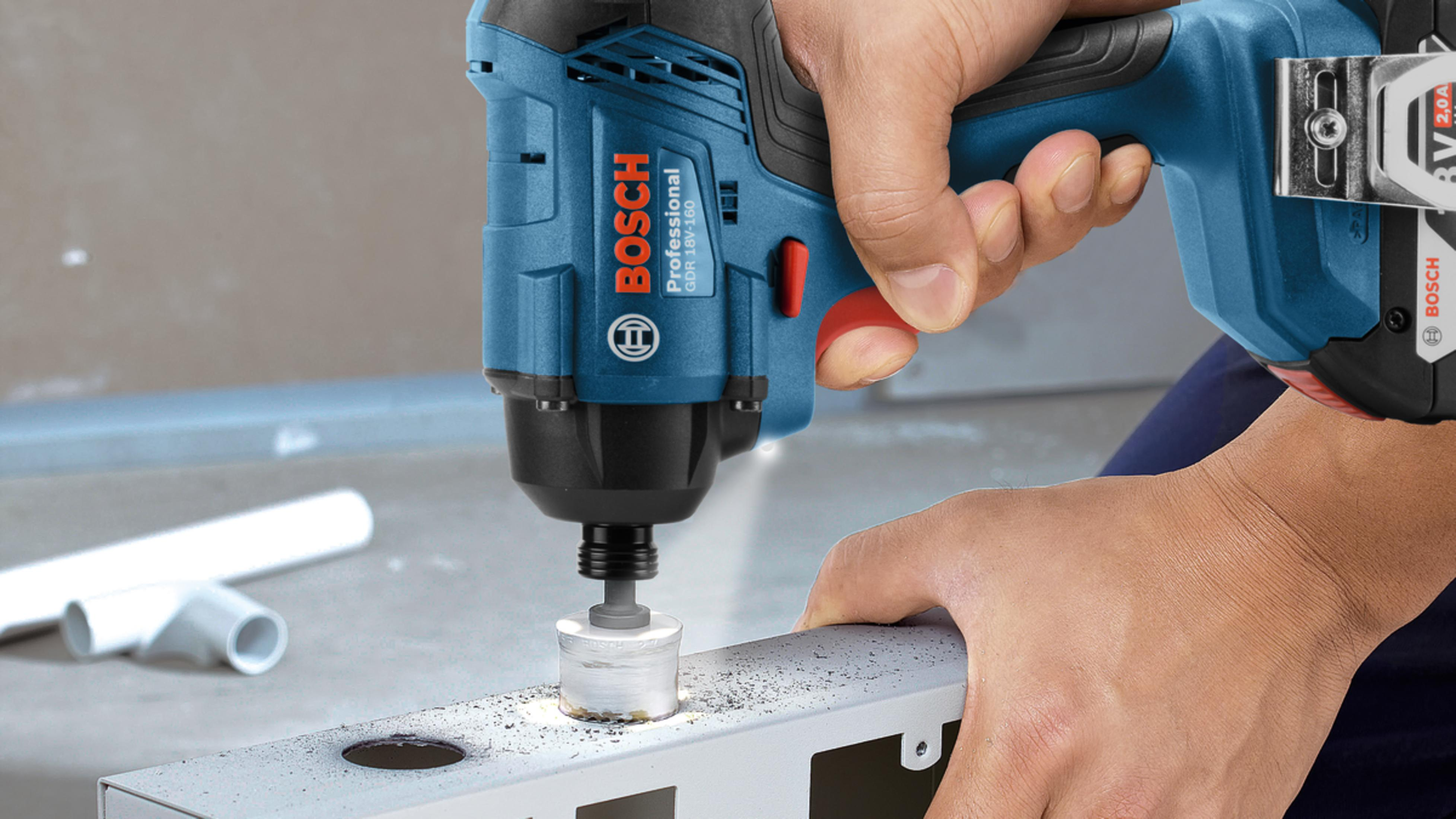 Mavi bir Bosch profesyonel akülü vidalama makinesiyle metal profile delik açan kişi.