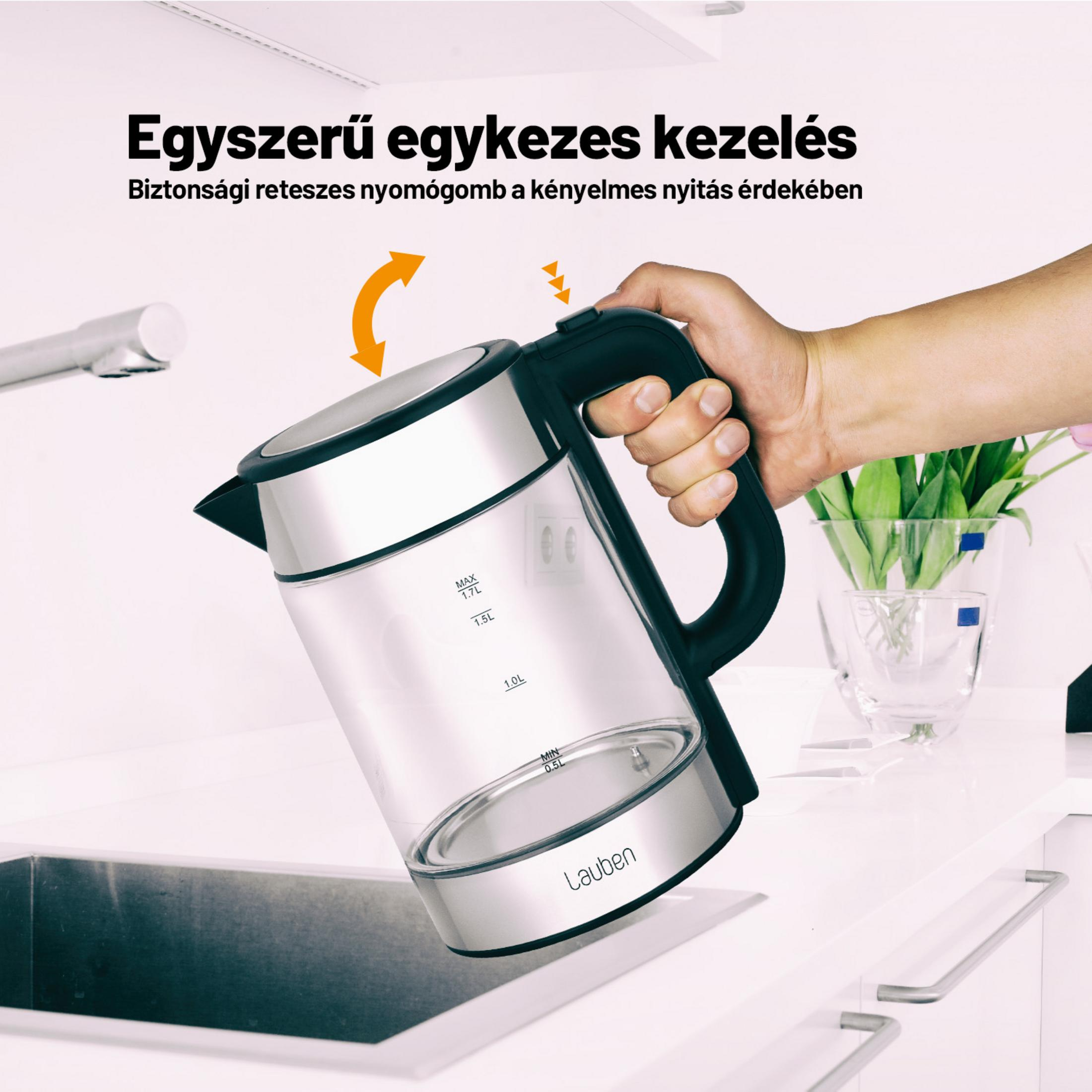 Hand hält einen silbernen Wasserkocher mit Glas und schwarzem Griff über einer Spüle.