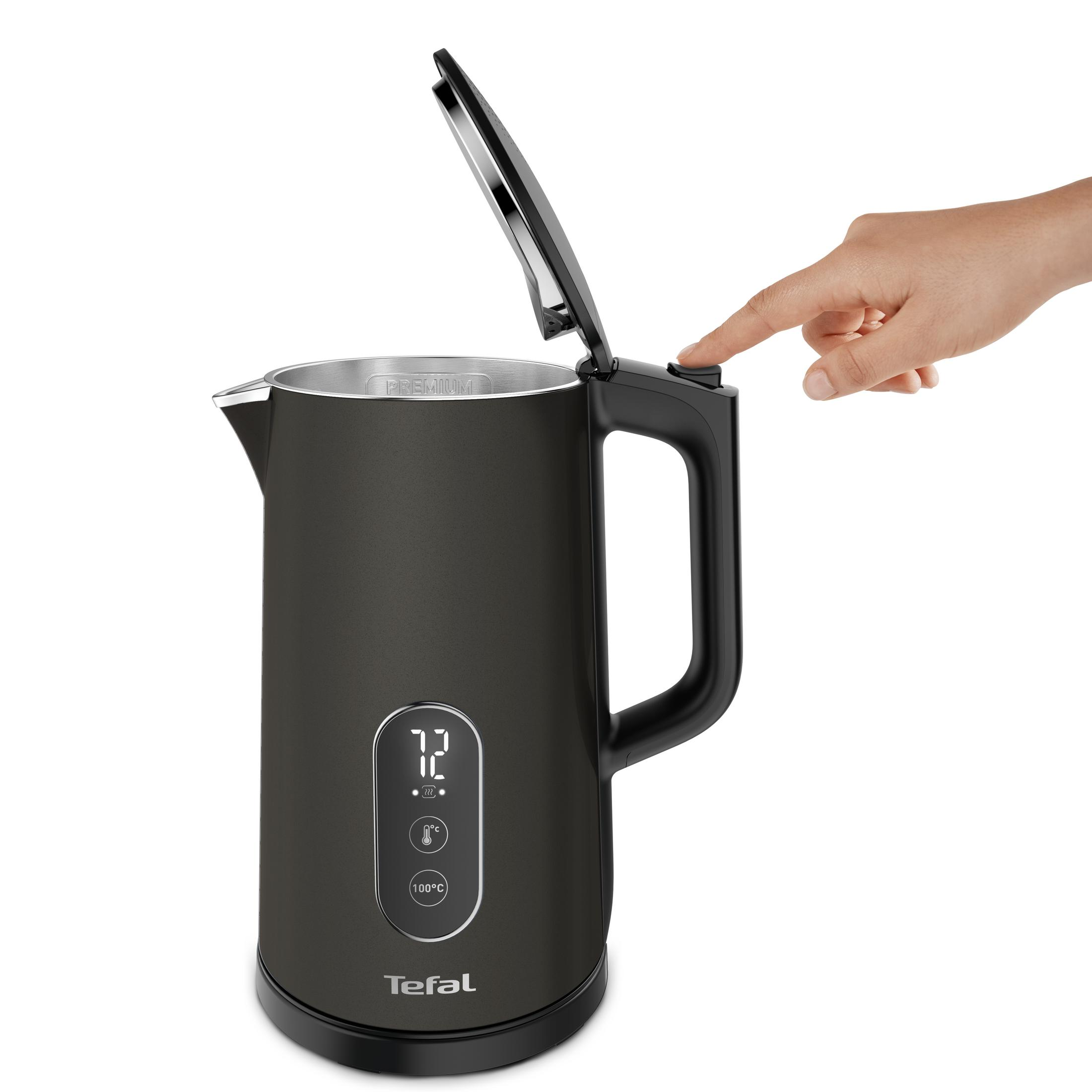 Ręka naciska przycisk na czajniku Tefal z otwartą pokrywką i wyświetlaczem cyfrowym.