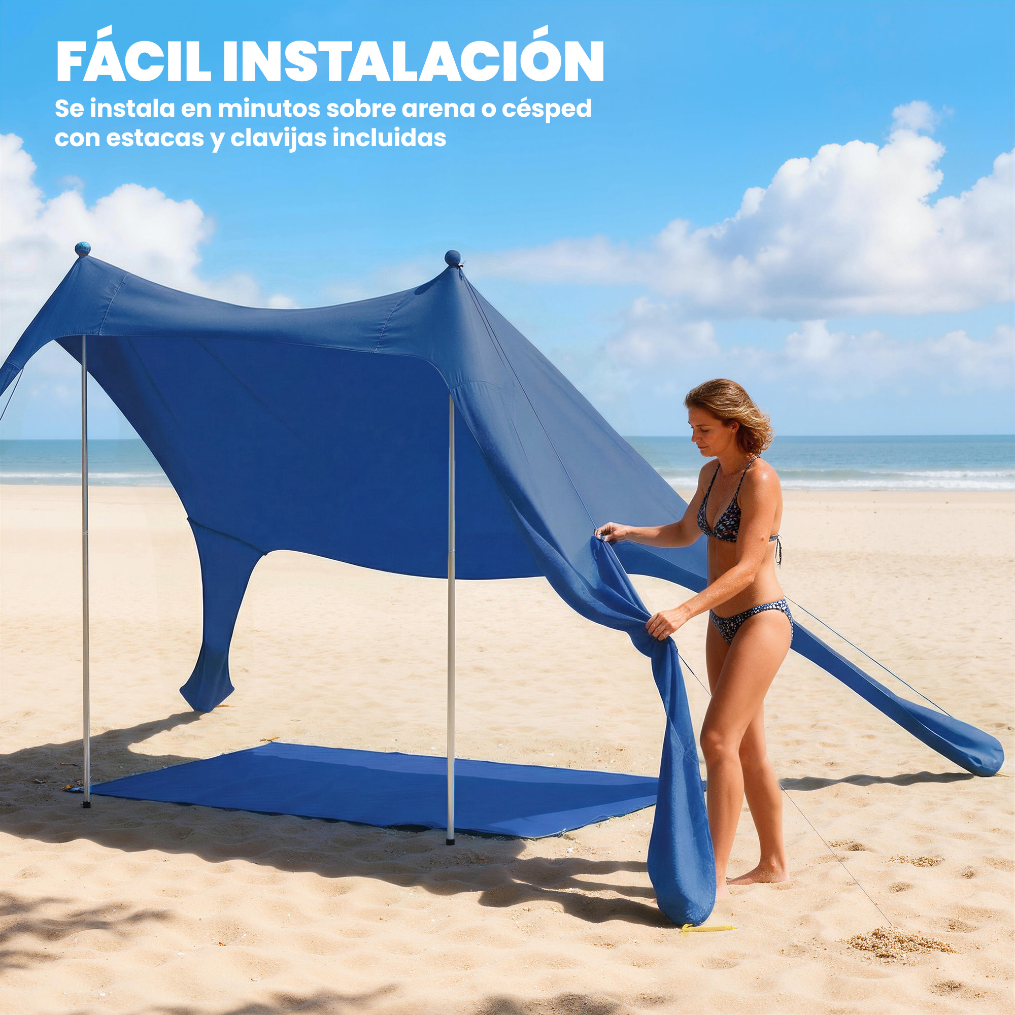 Una donna in bikini monta una grande tenda da mare blu sulla sabbia.