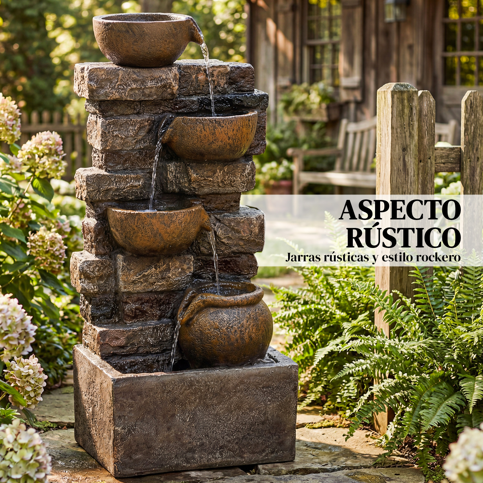 Una fontana da giardino in pietra rustica con quattro ciotole a cascata e acqua corrente, circondata da fiori.