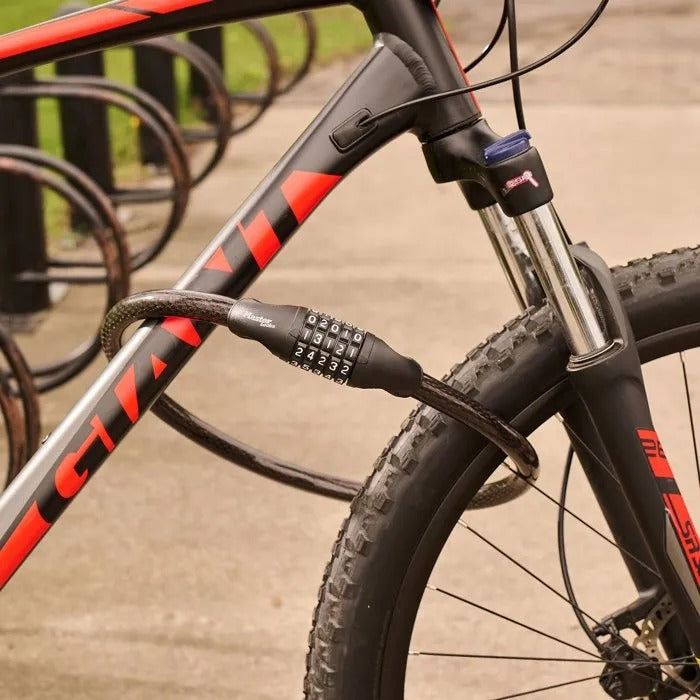 Ein schwarzes und rotes Fahrrad mit Zahlenschloss an einem Ständer.