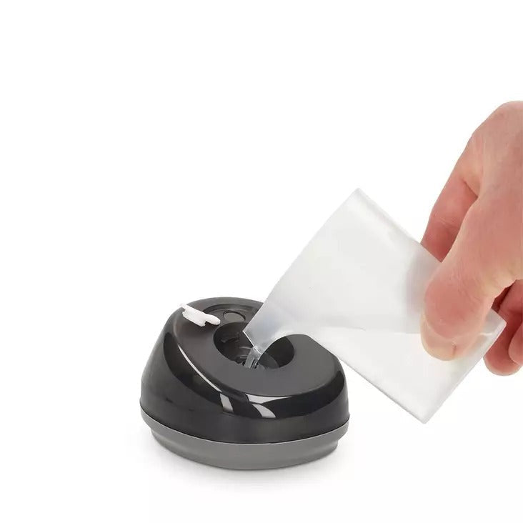 Una mano versa acqua da un bicchiere in un dispositivo su sfondo bianco.