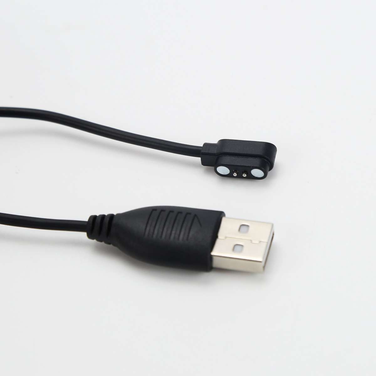 Fekete USB töltőkábel hagyományos USB-A csatlakozóval és mágneses töltőfejjel fehér háttér előtt.