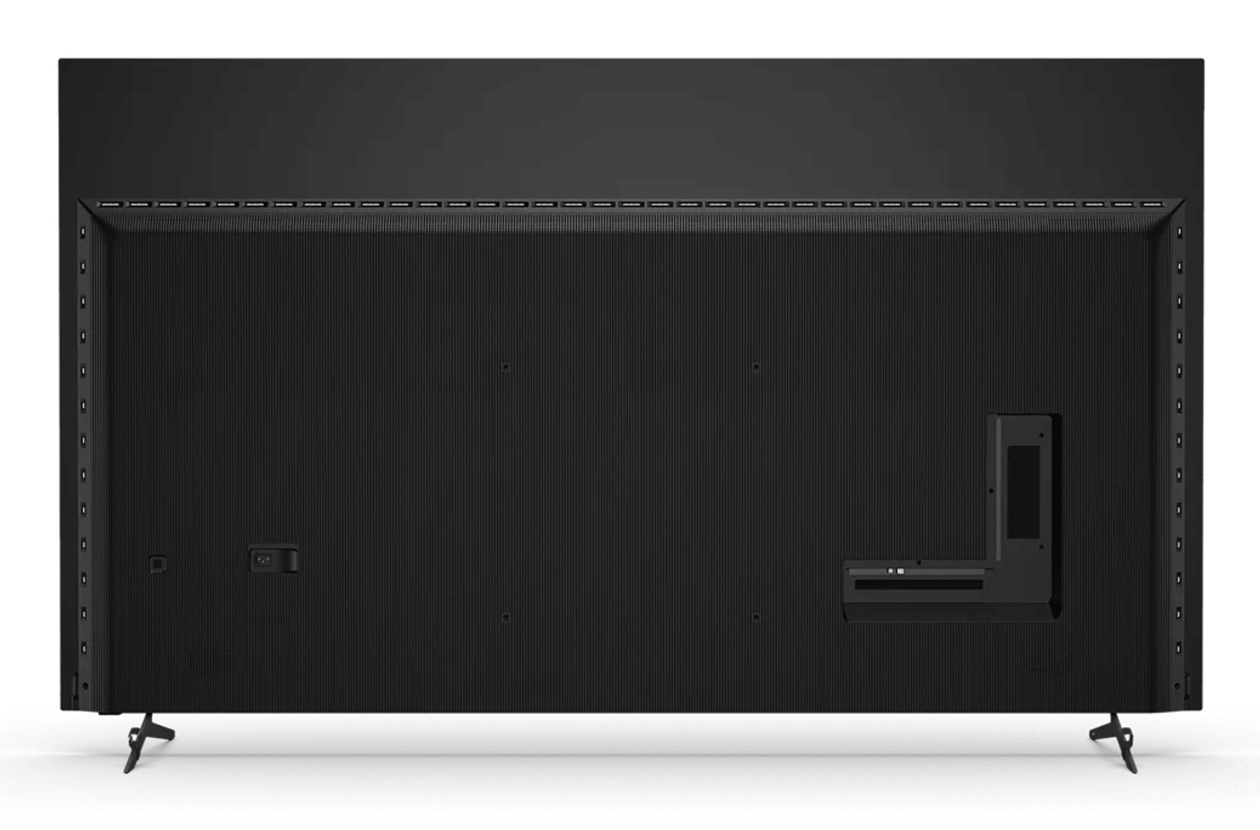 Vista trasera de un televisor negro moderno sobre una superficie blanca, mostrando ranuras verticales y puertos.